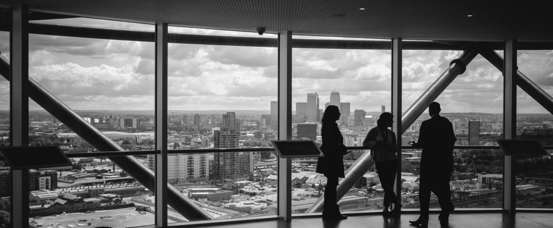 „Unternehmensberater im Gespräch mit Blick auf die Skyline – Darstellung von Interim Management, Unternehmensberatung und geschäftlicher Transformation.“