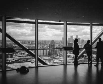 „Unternehmensberater im Gespräch mit Blick auf die Skyline – Darstellung von Interim Management, Unternehmensberatung und geschäftlicher Transformation.“